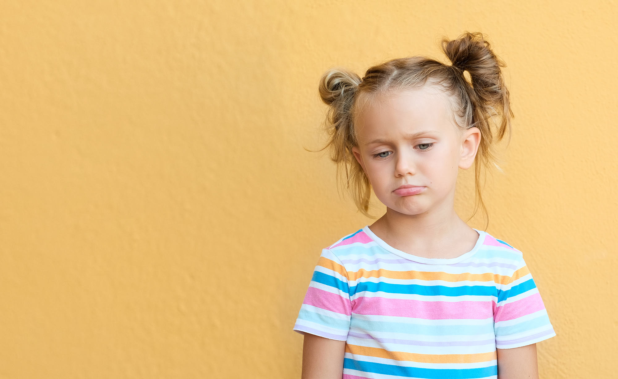 vecteezy_unhappy-little-girl-kid-isolated-over-yellow-studio_18747013